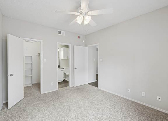 B1 bedroom with white walls, a ceiling fan, and a carpeted floor at Jefferson Place Apartments in Irving, TX