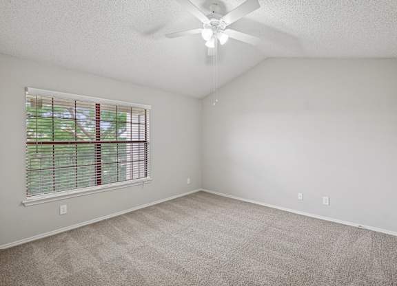 B1 bedroom with a ceiling fan, white walls, and a window at Jefferson Place Apartments in Irving, TX