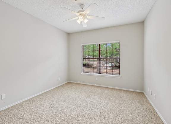 B2 bedroom with a ceiling fan and a window at Jefferson Place Apartments in Irving, TX