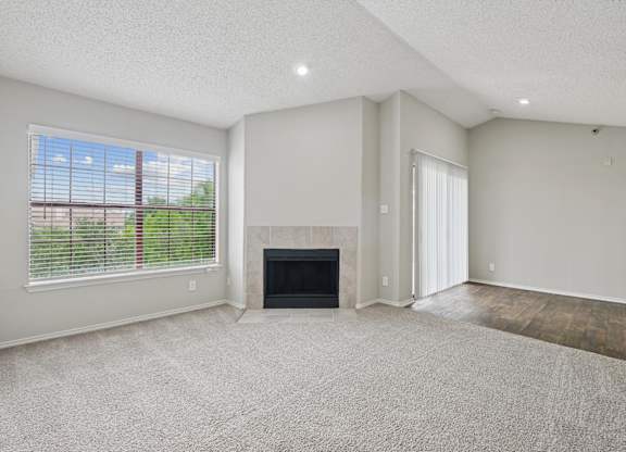 B2 living room with a fireplace and a large window at Jefferson Place Apartments in Irving, TX