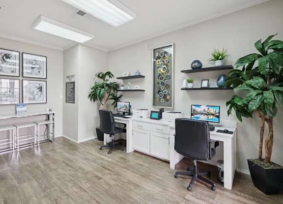 A business center with computers, printers, and potted plants at Jefferson Place Apartments in Irving, TX