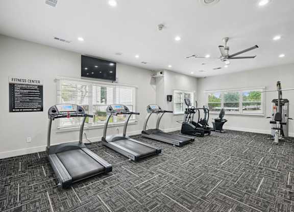 A fitness center with treadmills and strength training machines at Jefferson Place Apartments in Irving, TX