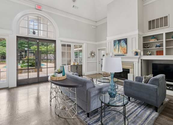 Resident lounge area with grey couches and a glass table at Jefferson Place Apartments in Irving, TX