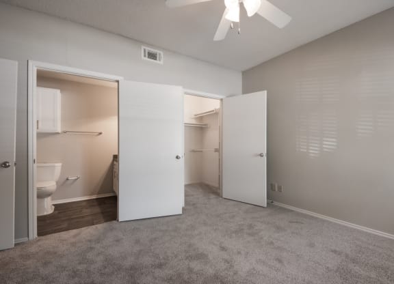 a bedroom with a ceiling fan and a closet