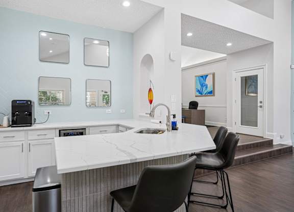 Clubhouse kitchen with a white countertop and a black chair.