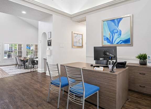 Leasing office with staff desk and two blue chairs at La Costa in Plano, TX