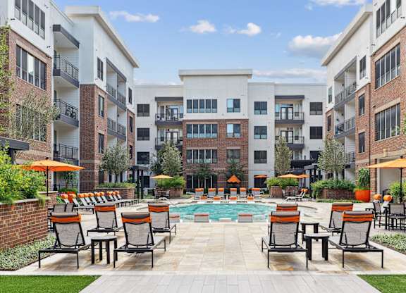 Our sparkling pool surrounded by lounge seats at Muse at Museum District apartments in Houston, TX