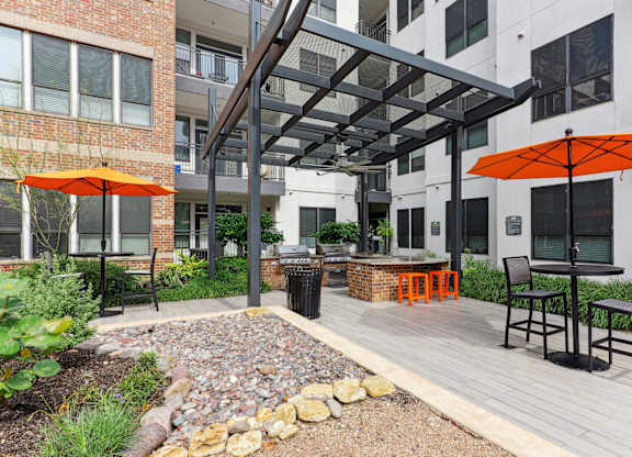 Outdoor grilling station under a pergola with two bbq grills at Muse at Museum District apartments in Houston, TX