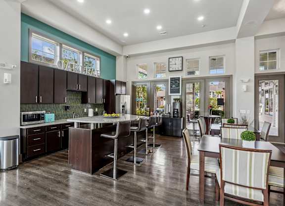 A clubhouse kitchen with a microwave, coffee station, fridge, and large island at Oakleaf Plantation Apartments in Jacksonville, FL