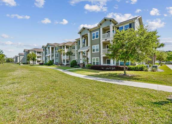 A grassy area in front of apartment buildings.