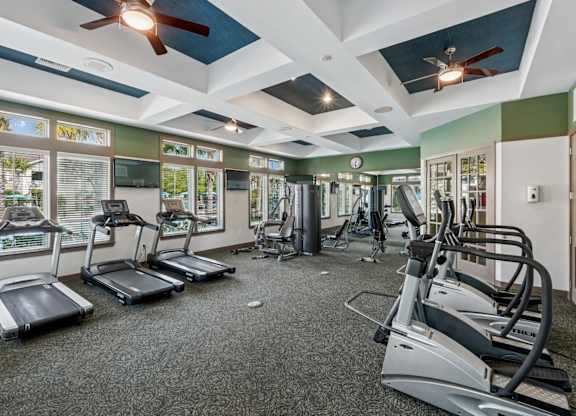 A gym with treadmills, elliptical machines, and other exercise equipment.