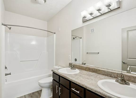 A white bathroom with a toilet, sink, and shower.