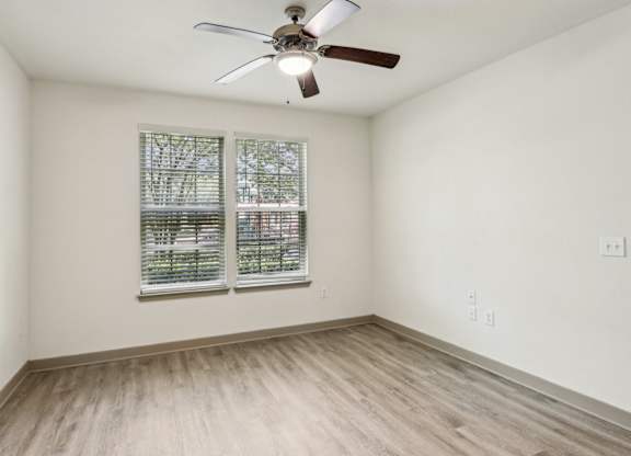 Royal Palm bedroom with a ceiling fan and a window with blinds at Oakleaf Plantation apartments in Jacksonville, FL.
