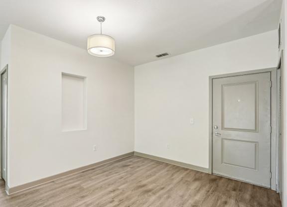 Royal Palm entryway with a wooden floor and white walls at Oakleaf Plantation Apartments in Jacksonville, FL