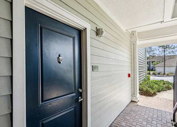 A dark blue door going into a Royal Plan floor plan type at Oakleaf Plantation apartments in Jacksonville, FL.