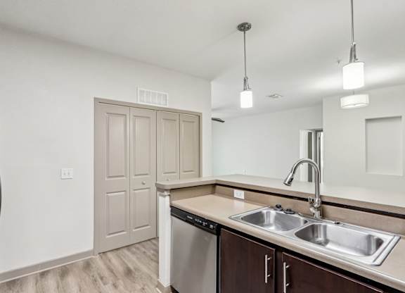 Royal Palm kitchen with a stainless steel dishwasher and a sink with a modern design at Oakleaf Plantation apartments in Jacksonville, FL.