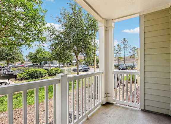 A view from the Royal Palm patio looking out to lush green trees and grass at Oakleaf Plantation Apartments in Jacksonville, FL