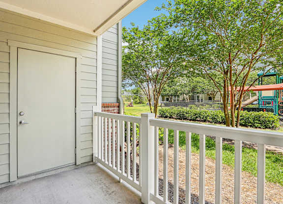 A Royal Palm fenced in patio looks out at the lush greenery at Oakleaf Plantation Apartments in Jacksonville, FL