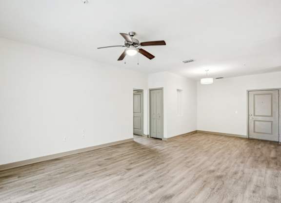 A room with a ceiling fan and wooden flooring at Oakleaf Plantation Apartments in Jacksonville, FL