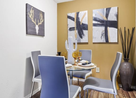 a dining room with a table and chairs and paintings on the wall