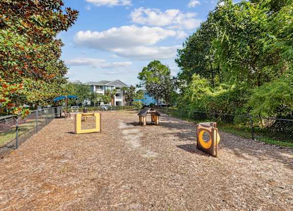 A fenced dog park with toys at Wynnfield Lakes Apartments in Jacksonville, FL