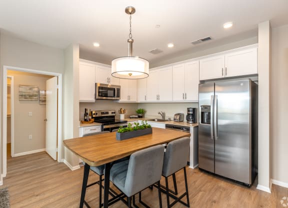 a kitchen with stainless steel appliances and a wooden table
