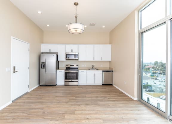 a spacious kitchen with white cabinets and stainless steel appliances