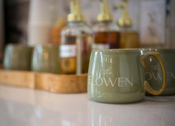 A green mug with the word "flowen" written on it.