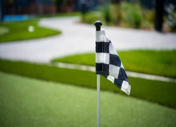 A checkered flag on a golf course.
