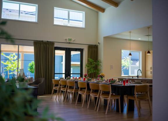 A dining room with a table set for a meal.