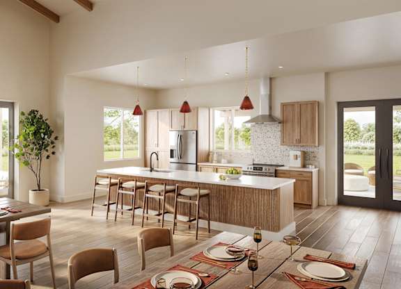 A modern kitchen with a dining table set for a meal.