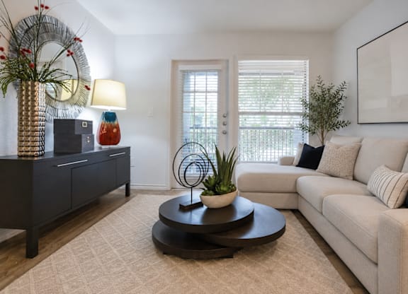 Living room with beige sectional sofa and black coffee table at Radius at the Domain Apartments, Austin