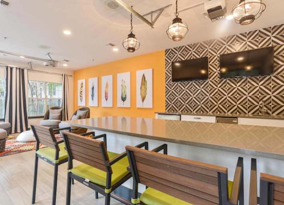 Community lounge with dining table and flat screen tvs at Radius at the Domain Apartments, Austin, TX 78758