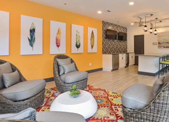 Community lounge with colorful artwork and wicker seating at Radius at the Domain Apartments, Austin, TX