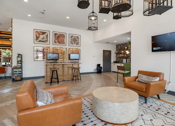 Modern clubhouse lounge with leather seating and decorative pendant lights at Radius at the Domain Apartments, Austin, TX 78758