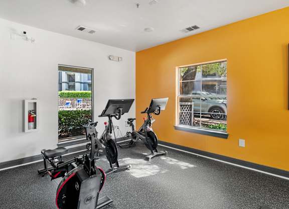 Fitness center with stationary bikes and workout equipment at Radius at the Domain Apartments, Austin, TX