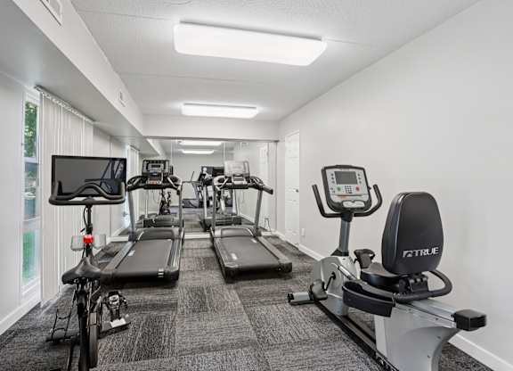 A gym with treadmills, exercise bikes, and elliptical machines.