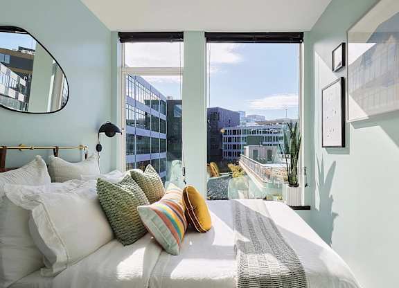 A bedroom with a large bed and a view of the city.