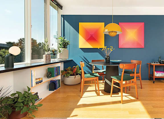 A dining room with a table and chairs.
