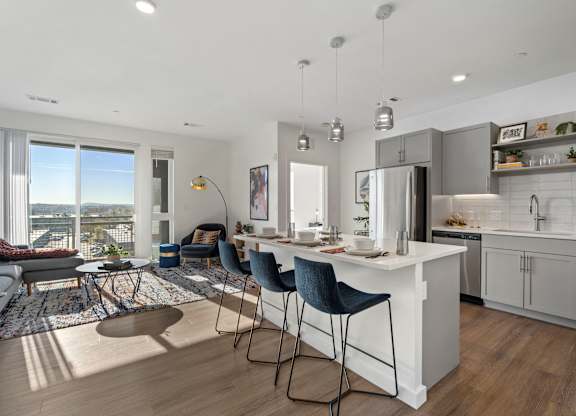 A modern kitchen with a breakfast bar and a view of the city.