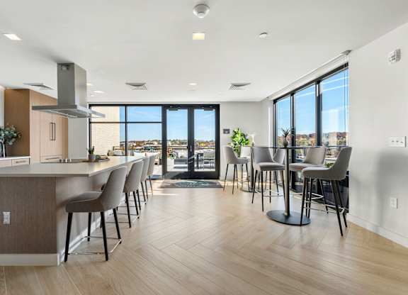 A modern kitchen with a long island and chairs.
