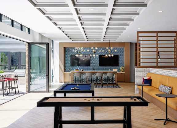 A billiard table is in the middle of a room with a pool table and a bar.