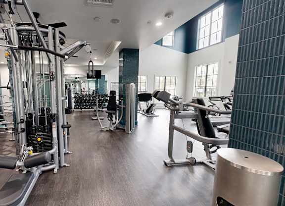 A gym with a variety of equipment including weights and cardio machines.