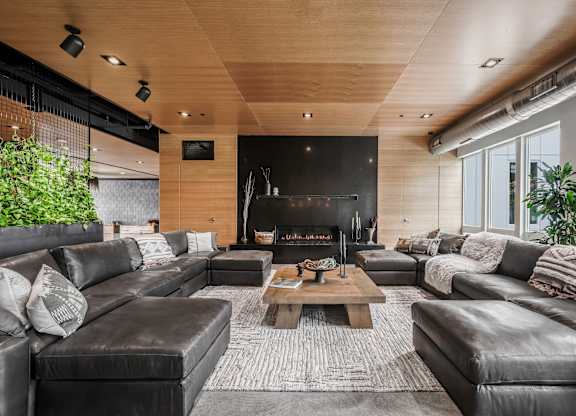 A modern living room with a fireplace and leather furniture.