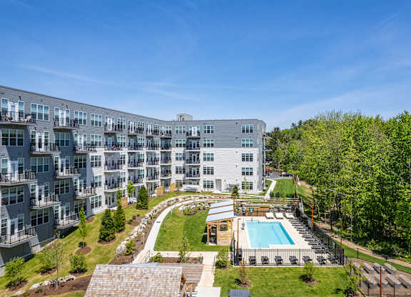 A large apartment complex with a pool and a landscaped courtyard.