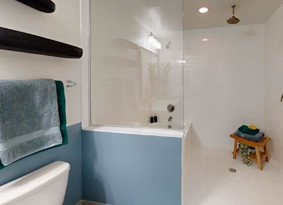 A small bathroom with a white toilet and a blue wall.