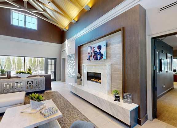A modern living room with a fireplace and a flat screen TV mounted on the wall.