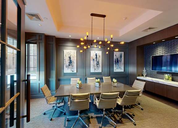 A conference room with a long table and chairs.