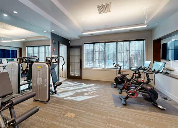 A gym with treadmills, exercise bikes, and other equipment.