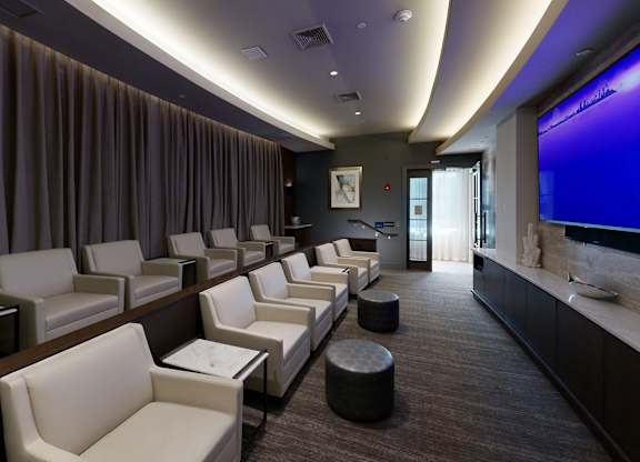 A row of white chairs are lined up in a room.